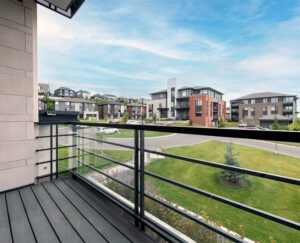 View from a balcony in Richardson Ridge, featuring a lush grassy area, highlighting the community's natural surroundings.