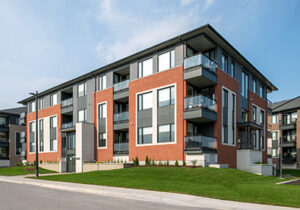 Large apartment building at Wateridge Village with an expansive parking lot in front.