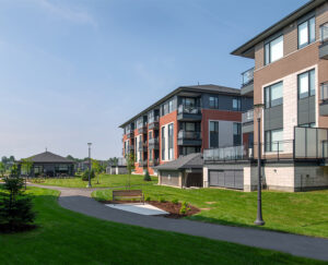 A serene park in Wateridge Village featuring a bench surrounded by a lush grassy area.