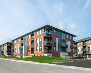 Overview of Wateridge Village, showcasing a large apartment building alongside a parking lot and street.